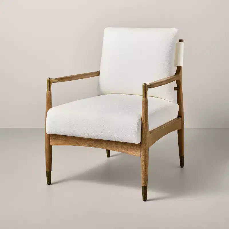 Sillón decorativo tapizado en bouclé con detalles de latón