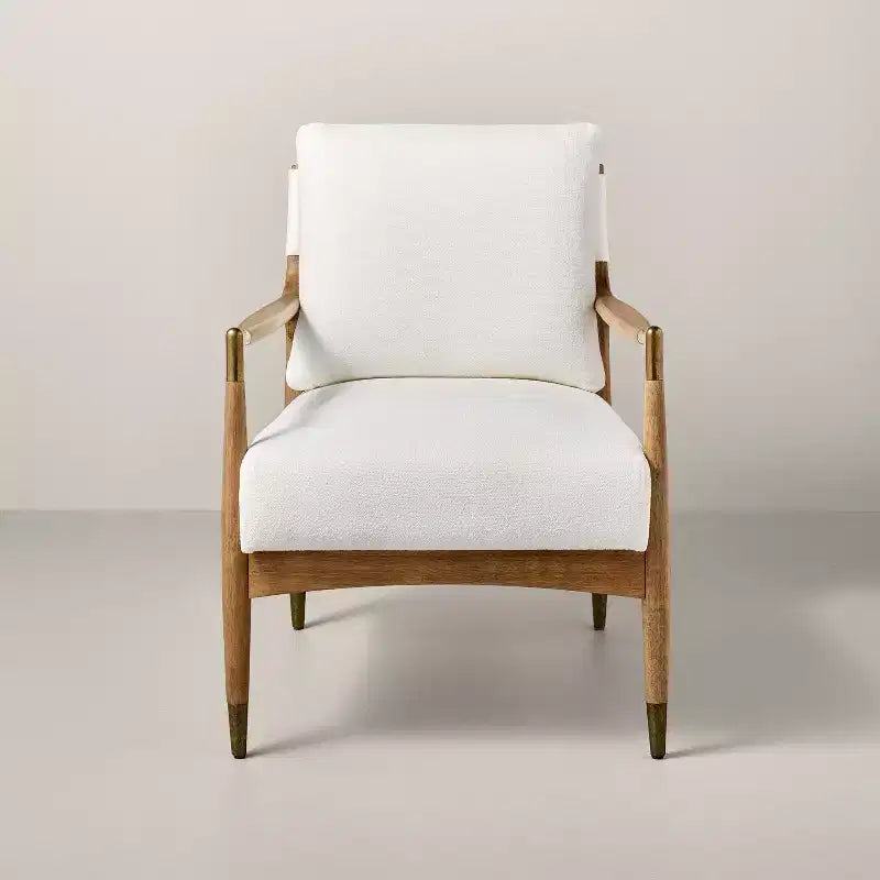 Sillón decorativo tapizado en bouclé con detalles de latón