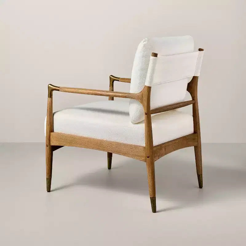 Sillón decorativo tapizado en bouclé con detalles de latón