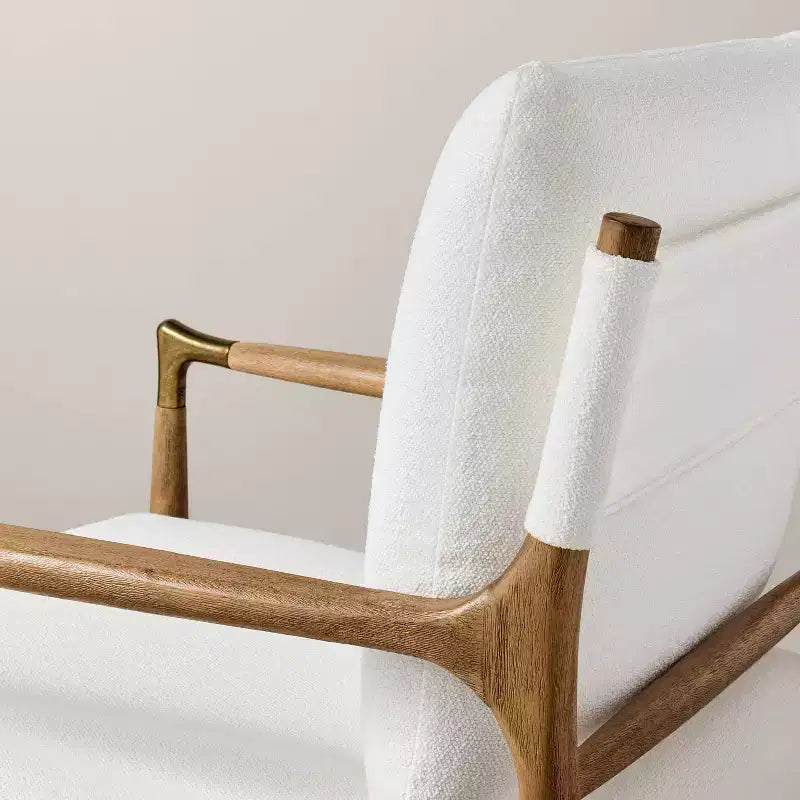 Sillón decorativo tapizado en bouclé con detalles de latón